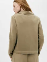 Camiseta tipo polo color beige, de manga larga y corte recto.
