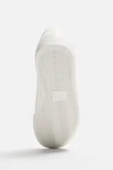 Zapatillas blancas de cuero sintético con cordones, forro interior y plantilla color beige.