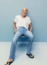 Pantalón de jean celeste de tiro medio, corte flare y bajo deshilachado.