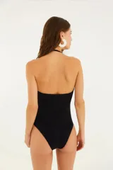 Traje de baño entero negro con textura floral, sin tirantes y escote en V.