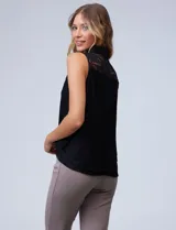 Blusa azul marino de encaje sin mangas, con cuello camisero y lazo al cuello.