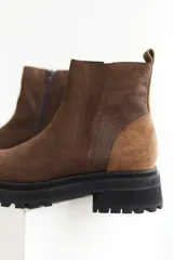 Botas de cuero negro con punta cuadrada, caña media y cierre lateral con cremallera.