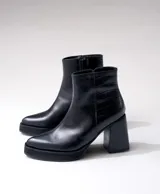 Bota corta negra de cuero vacuno, con taco de madera de 9 cm y plataforma delantera de 2 cm.