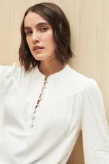 Camisa celeste de manga larga en viscosa suave, con cuello mao y botonadura parcial al frente. El detalle de frunces en los hombros y los puños abotonados le suman delicadeza y estilo.