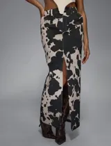 Falda larga de jean con estampado de vaca en blanco y negro, tiro alto, corte recto y abertura frontal.