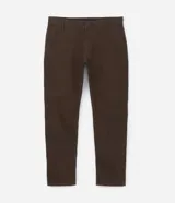 Pantalón de vestir marrón, de corte skinny, con bolsillos laterales y traseros. Se ajusta a la cintura con cinturón de cuero marrón.