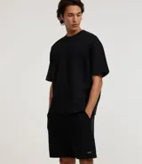 Bermuda masculina de corte slim fit, color marrón, confeccionada en algodón con felpa. Presenta cintura elástica con cordón ajustable y bolsillos laterales.