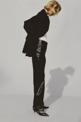 Pantalón de cuero sintético negro, de corte recto, tiro alto y cinco bolsillos.