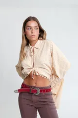 Cinto de cuero color rojo con hebilla metálica plateada y tachas decorativas. Hecho a mano en Uruguay.