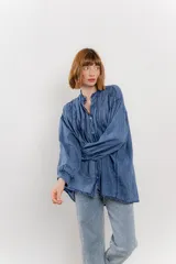 Camisa oversize blanca de algodón con pliegues frontales.