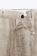 Pantalón de lino con estampado tie dye, tiro medio, cintura con trabillas y cierre frontal con cremallera, botón y ganchos metálicos.