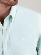 Camisa celeste de hombre, marca El Ganso, de corte regular fit, cuello button-down, manga larga con puño simple y logo bordado en el pecho. Confeccionada en tejido oxford compuesto por 93% algodón y 7% algodón reciclado.