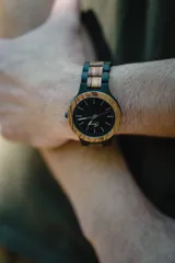 Reloj Vernoir con caja de madera de Zebrano y malla de Chacate Preto con incrustaciones de madera de Zebrano. Esfera negra con marcadores minimalistas en blanco y manecillas negras.