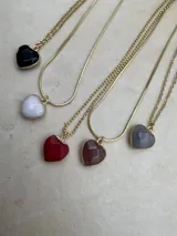 Collar con cadena dorada y dije en forma de corazón de piedra natural en varios colores: negro, blanco, rojo, marrón y gris.
