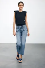Pantalón de jean celeste de tiro bajo, corte flare, cropped y cinco bolsillos.