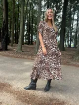 Vestido largo de fibrana y viscosa con estampado animal print, corte holgado, mangas cortas y ruedo con volantes.