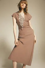 Vestido midi color beige con cuello solapa, escote en pico y manga corta. Cintura entallada con pliegues y cierre lateral con cremallera oculta.