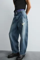 Pantalón de jean azul de corte amplio, con roturas y lavado gastado.