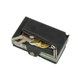 Billetera compacta de cuero negro con costuras verdes y mecanismo de eyección de tarjetas. Presenta el nombre "Baleine" grabado en la parte inferior frontal.