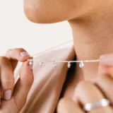 Gargantilla de plata 925 con cadena fina y múltiples circonias redondas engarzadas que cuelgan a lo largo de la pieza.