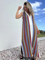 Vestido largo de tejido con diseño geométrico en tonos celeste, marrón, rojo y blanco. Tiene escote en V y aberturas laterales.