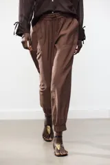 Pantalón jogger marrón de tiro alto con cintura elástica ajustable con cordones, bolsillos delanteros y puños elásticos en los tobillos.