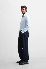 Camisa celeste de corte regular, con cuello italiano, mangas largas con puños abotonados y cierre frontal con botones.