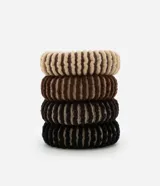 Set de cuatro gomitas de pelo con textura rayada en colores beige, marrón claro, marrón oscuro y negro.