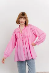 Camisa oversize blanca de algodón con pliegues frontales.