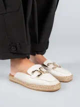 Sandalia mule color blanco con aplique metálico dorado y suela de yute.