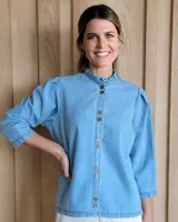 Camisa negra con mangas fruncidas, botones de nácar y pespuntes contrastantes.