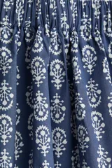 Pollera larga de algodón con estampado floral blanco sobre fondo azul, corte holgado, tiro alto y cintura elástica. Forrada.