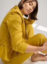 Blazer color mostaza de lino con corte estructurado, solapas con pespuntes y bolsillos con solapa.