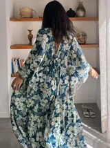 Vestido largo de polysilk con estampado paisley en tonos azul, celeste y dorado. Tiene escote en V, mangas largas acampanadas y corte amplio.