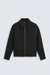Sobrecamisa negra de tejido con textura, corte regular, cuello solapa, manga larga con puños abotonados, bolsillos laterales y cierre frontal con cremallera.