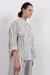 Camisa de manga larga con cuello mao, botones en el frente, fit holgado y dos bolsillos en la delantera.