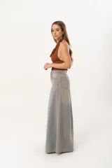 Jean súper campana de tiro alto, color celeste vintage, con pierna extra ancha y caída fluida. Cuenta con bolsillos delanteros y traseros, y cierre frontal con cremallera y botón metálico.