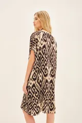 Vestido corto de viscosa con estampado ikat en tonos beige y marrón. Tiene corte amplio y escote en V.
