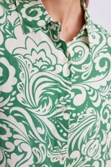 Camisa de manga larga con cuello clásico y estampado floral en tonos verde y blanco.