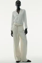 Camisa marrón de satén con viscosa, cuello solapa, manga larga con puños y cierre frontal con botones.