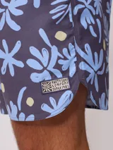 Short de baño celeste con estampado de flores abstractas en azul y amarillo.