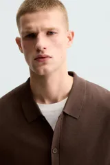 Camisa marrón de punto con viscosa, corte relaxed fit, cuello solapa, manga corta, rib a contraste y cierre frontal con botones.