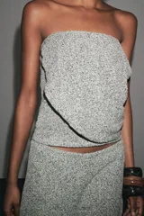 Top palabra de honor de tejido bouclé color gris con detalle de pliegues delanteros.