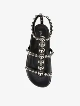 Sandalias blancas con tachas plateadas, forro y suela sintética, con cierre de velcro.