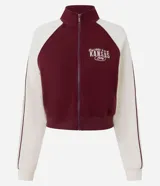 Saco femenino de poliviscosa, color blanco con mangas raglán marrones y ribetes blancos. Tiene cuello alto, cierre frontal de cremallera y bordado lettering "Kansas City" en el pecho.