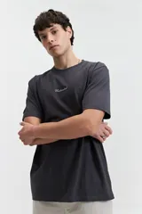 Remera color crema de manga corta con estampado de águilas y texto distorsionado en la espalda. Corte regular.