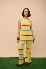 Pantalón amarillo tejido en punto con rayas horizontales rojas y turquesas.