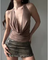Top negro con escote halter profundo y detalle de tachas plateadas.