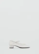 Zapato blanco con tacón bloque, tejido de malla semitransparente, cierre de hebilla y punta redonda.