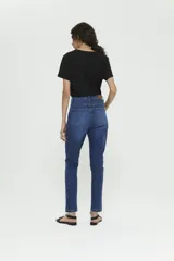 Pantalón jean azul de tiro caído, calce confort, pierna angosta en tobillo, detalles en bolsillos y canesú trasero. Lavado stone con bigotes y leve localizado.